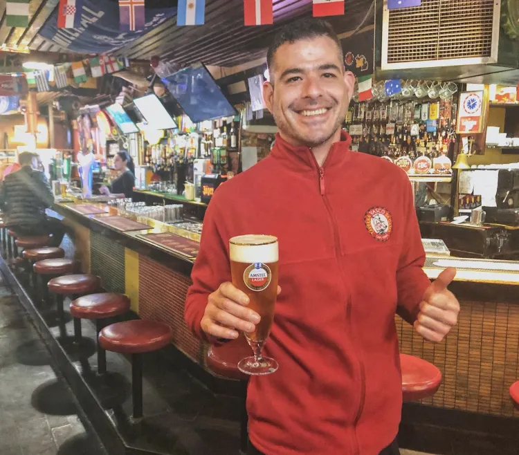 A barman at Vasco’s holding a glass of Castle tank beer