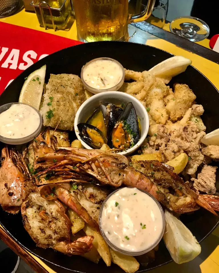 A seafood platter with mussels, calamari and sauces