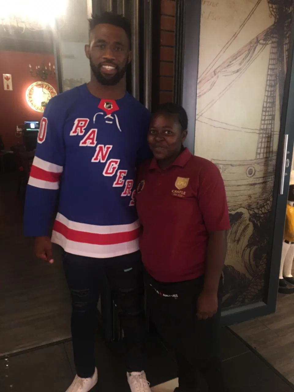 Siya Kolisi standing with a staff member